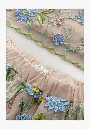 Rosa nätstruktur med blommigt broderi i blått, gult och grönt. Elastiskt midjeband med volangkant och "NEXT"-etikett. Mjuk textur.