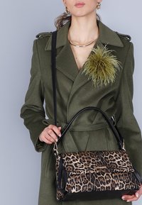 Borsa a tracolla con stampa leopardo e base in pelle nera, dotata di una pattina frontale, una maniglia elegante e dettagli in metallo dorato a contrasto.