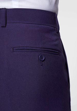 Pantaloni sartoriali blu navy con frontale piatto, dotati di tasca laterale con chiusura a bottone e tessuto liscio e texturizzato in un design aderente.