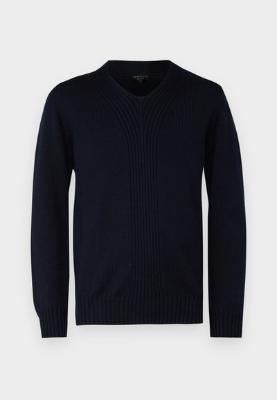 Tumši zila adīta džemperis ar V-veida kakladu, kuram ir vertikālas ribots tekstūra krūtīs un ribotas aproces un apakšmalas.