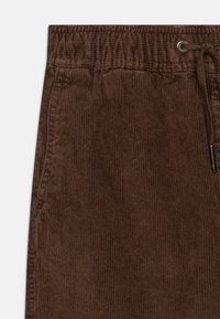 Bruine corduroy shorts met een textuur oppervlak, elastische tailleband en trekkoordsluiting. Bevat subtiele verticale ribbels voor extra detail.