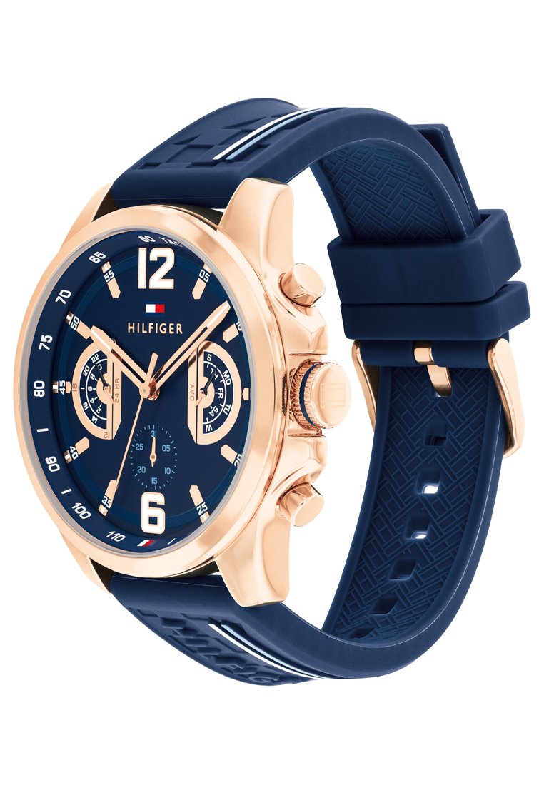 Zegarek z granatowym silikonowym paskiem i różowozłotą stalową obudową; okrągła tarcza ma granatowy cyferblat, białe znaczniki godzin oraz podwójne subtarcze.