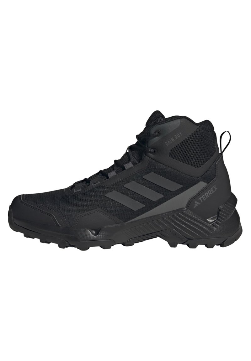 Chaussure de randonnée montante noire avec semelle texturée, trois bandes latérales, tissu en mesh et languette à l'arrière pour usage extérieur.