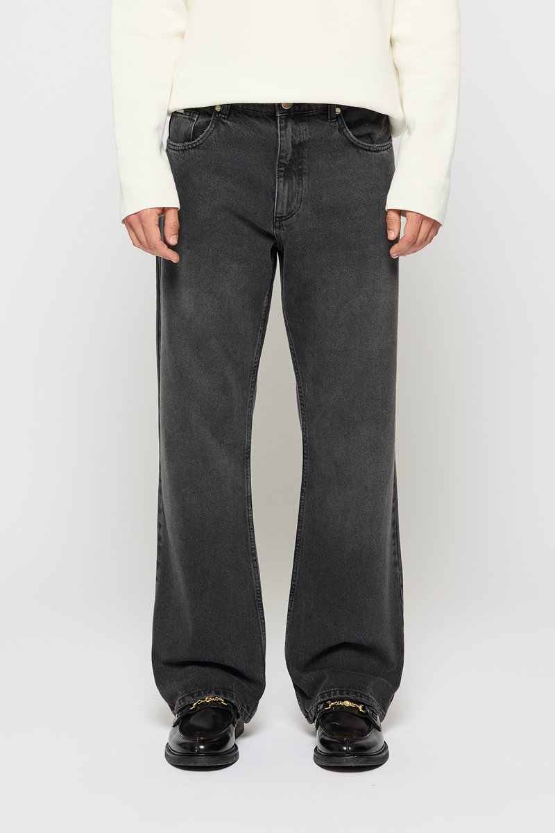 Sorte vidde jeans med en falmet finish, der har fem lommer, knaplukning og kontrastsyning på en ensfarvet baggrund.