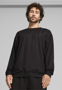 Schwarz sweatshirt mit langen Ärmeln aus weichem Material, mit Rundhalsausschnitt, überschnittenen Schultern und minimalem Textdetail auf der Vorderseite.