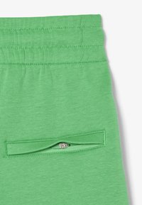 Gröna joggarbyxor med en slät textur, elastisk midja och en zippered ficka på sidan för extra funktionalitet.