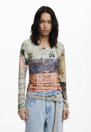 Long-sleeve fitted top featuring a multi-patterned design in soft, lightweight fabric; colors include beige, blue, orange, and floral accents.