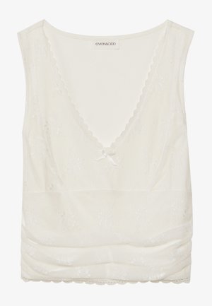 Camisole blanche avec un délicat liseré en dentelle, décolleté en V, nœud décoratif au centre, et détails froncés en bas.