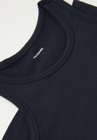 Námorně modrý tílko vyrobené z jemné, elastické tkaniny; má zaoblený výstřih a značkovou etiketu "TEZENIS" poblíž výstřihu.