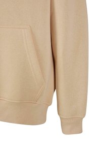 Felpa beige con tasca a marsupio, polsini a coste e una texture morbida. Il tessuto sembra spesso e caldo, adatto per un abbigliamento casual.