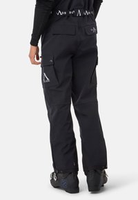 Schwarze Schnee-Hosen mit Cargo-Taschen, verstellbarem Bund und Logo-Details; entworfen für Winteraktivitäten; hochwertiger Stoff und lockere Passform.