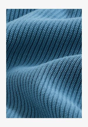 Zila ribota adīta auduma ar teksturētu rakstu, kas parāda dažādas zila toņus un mīkstas līnijas, radot viļņainu izskatu.