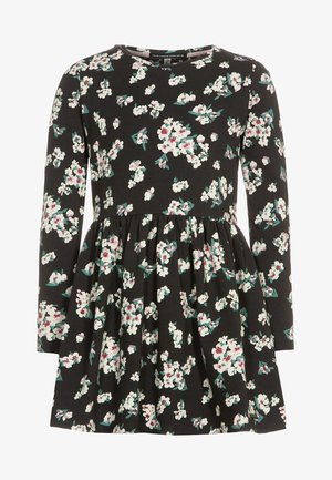 Czarna sukienka z długim rękawem, z marszczonym taliowaniem oraz białym i różowym wzorem kwiatowym rozmieszczonym na tkaninie.