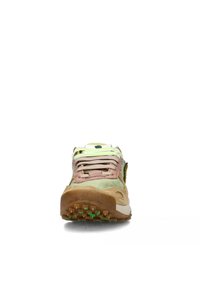 Zapatilla con parte superior de ante beige, detalles en verde pastel, cordones rosas y una suela de goma texturizada con clavos verdes para mayor tracción.