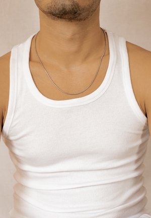 Mann trägt ein weißes, geripptes Tanktop und eine dünne silberne Halskette, zeigt Hals- und oberen Brustbereich.