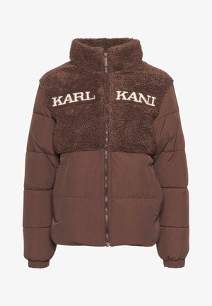 Pruun puffjakker kunstkarusello ülemise osa, kõrge krae ja brodüüritud "KARL KANI" tekstiga. Lukuga sulgemine ja elastsed varrukaotsad.