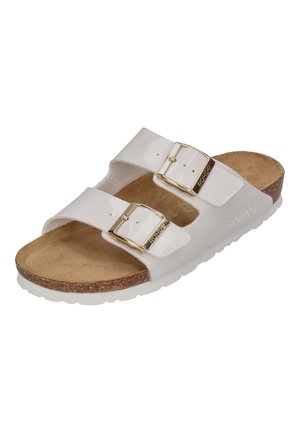 Hvide sandaler med to stropper, der har en blank finish, guld spænder, en kork-sål og en hvid gummisål.