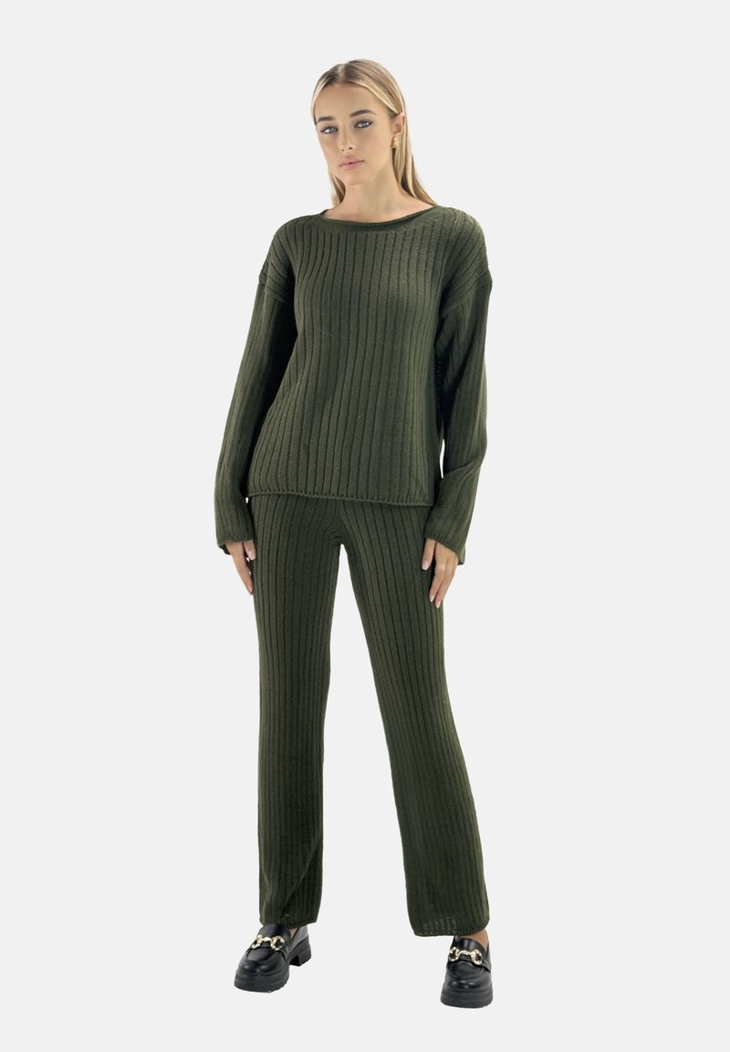 Zestaw składający się z oliwkowo-zielonego swetra z ribbowanym splotem i pasujących spodni. Posiada szeroki dekolt w łódkę oraz luźny krój. W zestawie noszone czarne baleriny.