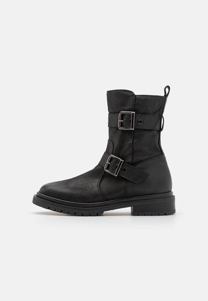 Bottine noire en cuir, dotée de deux boucles argentées, d'un bout rond et d'une semelle crantée robuste avec un petit talon.