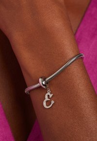 Zilveren bedelarmband met een flexibele, design, voorzien van een ampersand-symbool en een kleine diamantaccent. Gelaagd metalen band.