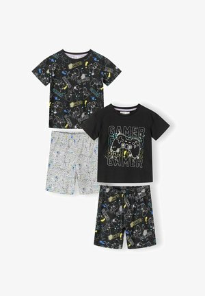Deux ensembles de pyjamas courts pour enfants avec imprimés de manettes de jeu ; un ensemble avec un haut noir et un texte multicolore, l'autre avec un short à motif éclaboussures noir et blanc.