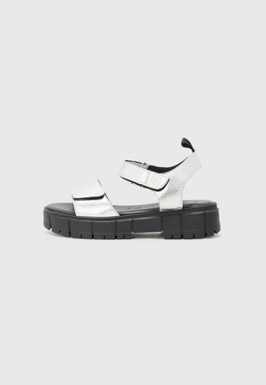 Silver metallic open-toe sandal with black chunky rubber sole and two adjustable Velcro straps, side view on a plain background.