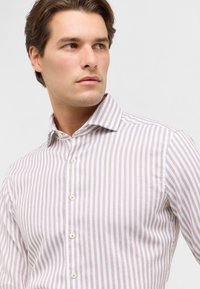 Wit en tan gestreept shirt met een button-down kraag, met een gladde textuur en een subtiele glans. De knopen zijn licht van kleur en rond.