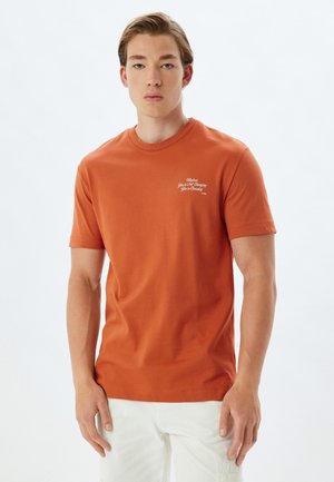Herre kortærmet orange bomulds t-shirt med rund halsudskæring og hvid tekstdetalje på brystet. Glat tekstur, almindelig pasform.