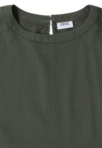 Haut en tissu texturé vert foncé avec col rond et petite fente dans le dos, avec une étiquette blanche indiquant "CECIL".