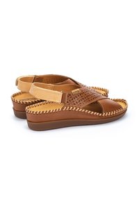 Sandalias de cuero marrón con diseño perforado, tira en contraste en tono bronceado y detalles trenzados a lo largo de la suela. Tira en el talón ajustable para un mejor ajuste.