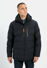 Czarna kurtka puchowa z kapturem, z zapięciem na zamek, kieszenią na piersi i dwiema kieszeniami z przodu. Gładki materiał o pikowanym wykończeniu.