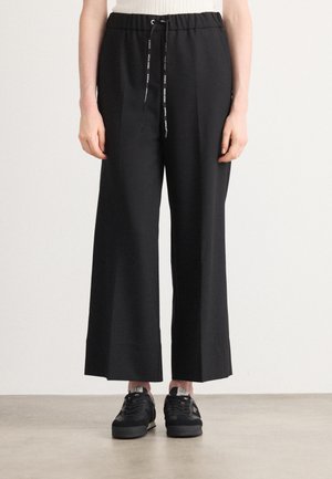 Zwarte wijde broek met een elastische tailleband en een trekkoord. Gladde stof met een ontspannen pasvorm en een schoon, minimalistisch ontwerp.