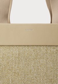 Beige geflochtener Handtasche mit einem strukturierten Boden und einer glatten Lederoberseite. Verfügt über ein silbernes, geprägtes Logo. Inklusive breiter Stoffriemen.