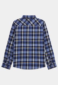 Niebieska koszula w kratę z białymi i żółtymi akcentami, z długimi rękawami, mankietami na guziki i ostro zakończonym kołnierzem. Materiał wydaje się bawełniany z teksturowanym wykończeniem.