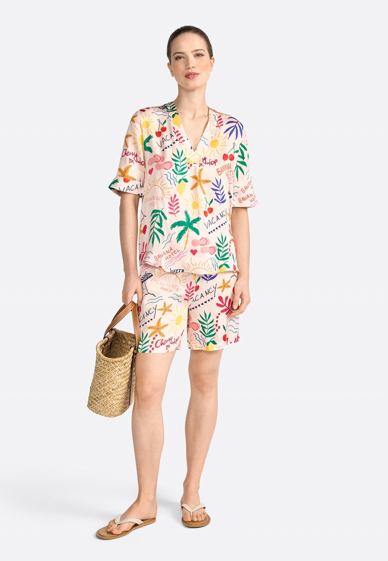 Kortärmad, V-ringad, rosa mönstrad skjorta med tropiska motiv, matchad med motsvarande shorts. Väska i vävt material och flip-flops kompletterar outfiten.