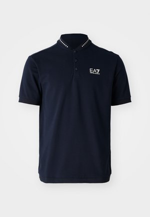 Polo shirt blu navy con colletto a maglia stretta, tre bottoni e dettagli in metallo. Presenta un logo ricamato EA7 sul lato sinistro del petto.