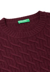 Maglione a maglia color bordeaux con un motivo a treccia testurizzato e scollo a coste. Presenta un'etichetta verde con la scritta "UNITED COLORS OF BENETTON."