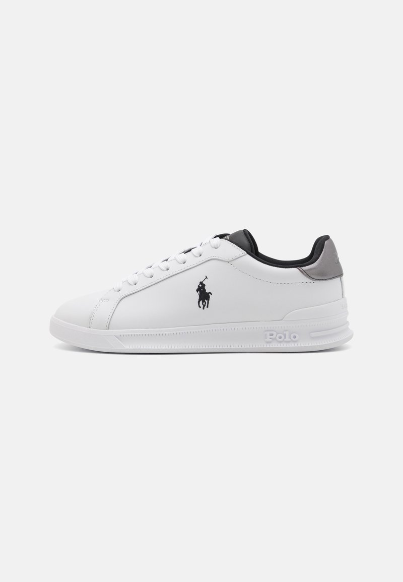 White leather sneakers with black and grey accents, featuring a lace-up design, signature logo, and textured rubber sole.