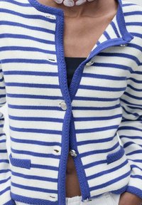 Cardigan a righe blu e bianche con chiusura a bottoni, due tasche frontali, polsini a coste e maglia con trama texture.