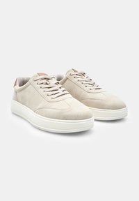 Beežist nubukist tennisajad, millel on sile tekstuur, valge kummist tallad ning pruuni nahka aktsendid kandadel ja keeletel. Klassikaline liputamisdisain.