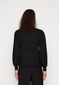 Maglione nero a maniche lunghe con maniche a sbuffo raccolte, polsini e orlo a coste, e texture liscia, visto da dietro.