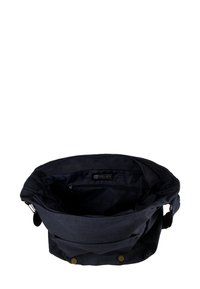 Navy canvas bag with a spacious interior, featuring a zippered pocket, two snap closures on the front, and a textured fabric exterior.