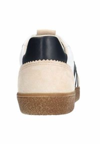 Baskets avec un dessus en cuir blanc et des accents noirs, un talon en daim beige et une semelle en caoutchouc texturée pour une meilleure adhérence.