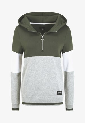 Grüner Kapuzenpullover mit Viertelreißverschluss, grau-weißer Farbblockgestaltung und Logo-Patch am unteren Saum. Der Stoff hat eine weiche Textur.