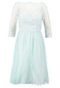 Robe avec une jupe en tulle mint clair, des manches trois-quarts transparentes et un corsage en dentelle brodé. Des motifs floraux accentuent le décolleté.