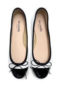 Ballerine bicolore in bianco e nero con una superficie in pelle liscia, punta arrotondata, cappuccio in pelle verniciata nera e dettaglio di fiocco in raso nero.