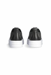 Sneaker in mesh nero con un design testurizzato, dotate di un tallone in pelle nera liscia e una suola chunky bianca. Fettuccia sul retro per facilitare la calzata.