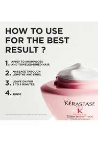 Masque capillaire Kérastase Genesis dans un pot rond rose avec un couvercle blanc. Inclut les instructions d'utilisation en texte gras à côté du produit.