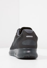 Sneaker sportivo nero con tomaia in mesh testurizzato, accenti grigi a contrasto, colletto imbottito e suola flessibile e ammortizzata.