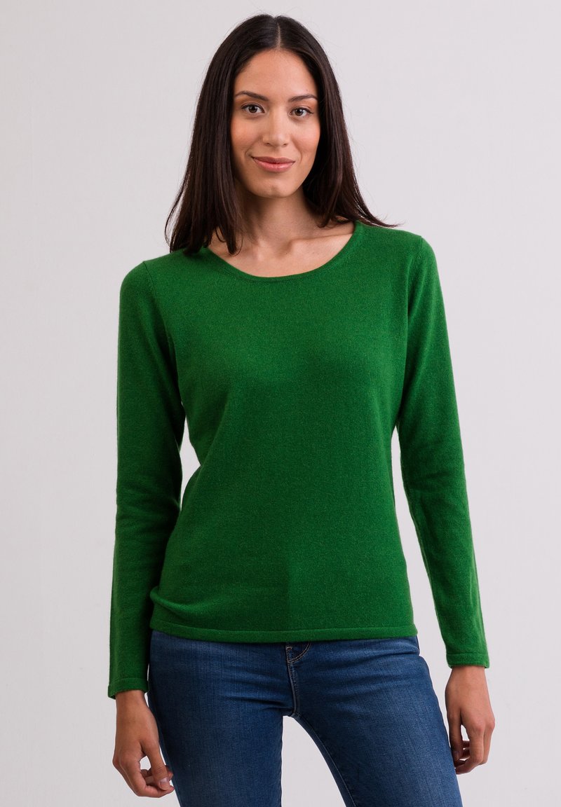 Grön långärmad tröja med rund halsringning, gjord av mjukt material, bärs med blåjeans, med en slät textur och figurnära design.